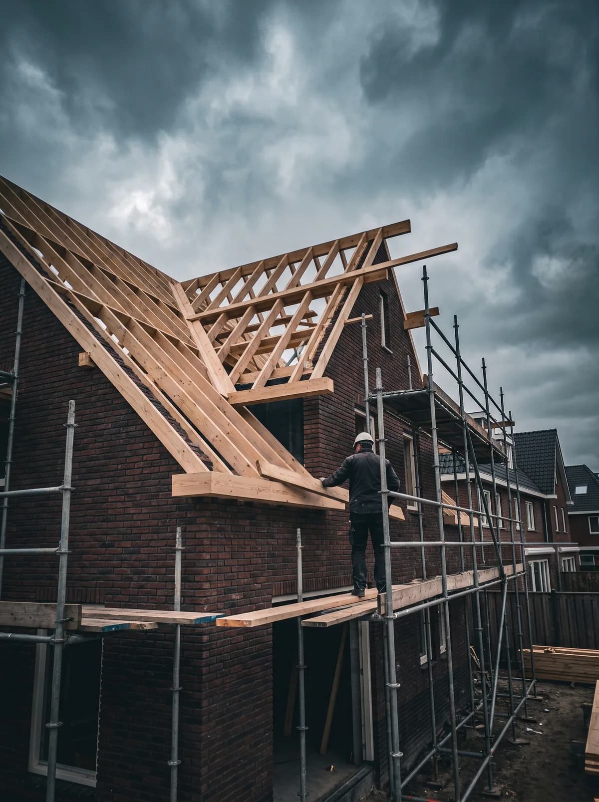 Timmerman werkt aan de houten dakconstructie van een aanbouw