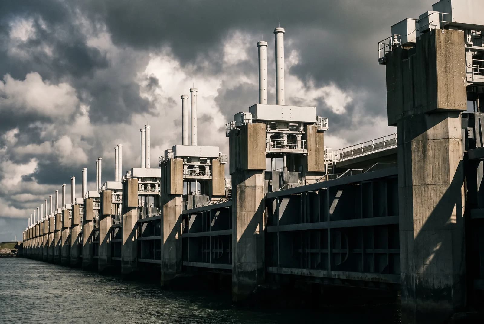 De Oosterscheldekering in Zeeland onder een dramatische wolkenlucht